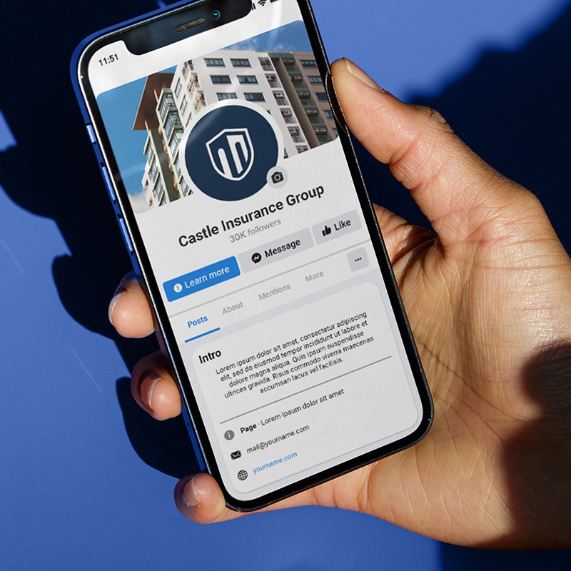 Hand holding a smartphone showing Castle Insurance Group’s branded Facebook profile.